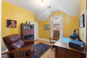 Office area featuring light hardwood / wood-style floors and vaulted ceiling