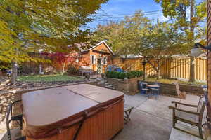 View of patio featuring an outdoor structure and a hot tub