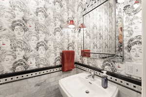 ½ Bathroom featuring tile walls and sink