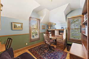 Office space featuring light hardwood / wood-style flooring and vaulted ceiling