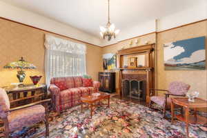 Living room with a notable chandelier and a tile fireplace