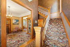 Stairs with hardwood / wood-style flooring and a notable chandelier