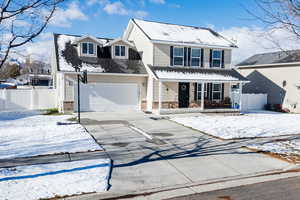 Front facade featuring a porch and a two car garage