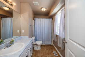 Full bathroom featuring tile patterned flooring, vanity, toilet, and shower / tub combo in the master bedroom.