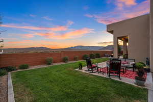 Yard at dusk featuring a mountain view and a patio area