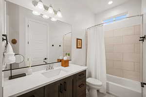 Full bathroom with vanity, toilet, and shower / bath combo with shower curtain