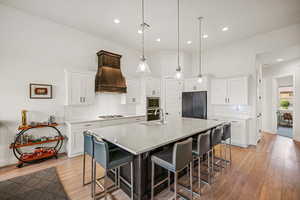 Kitchen featuring white cabinetry, sink, a kitchen island with sink, appliances with stainless steel finishes, and light wood-type flooring