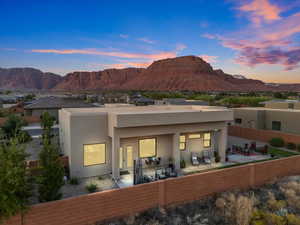 Back house at dusk with a mountain view and a patio