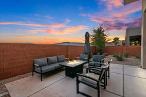 Patio terrace at dusk featuring an outdoor living space with a fire pit