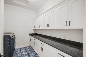 Laundry room with washing machine and clothes dryer and cabinets