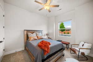 Bedroom with ceiling fan and light colored carpet