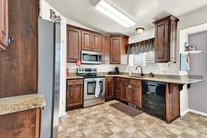 Kitchen featuring sink, stainless steel appliances, and a breakfast bar area