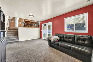 Carpeted living room with a textured ceiling