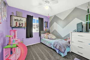 Carpeted bedroom featuring ceiling fan