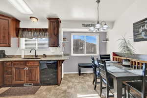 Kitchen featuring a wealth of natural light, dishwasher, pendant lighting, and sink