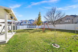 View of yard with a trampoline and a playground