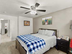 Carpeted master bedroom featuring a ceiling fan and box window