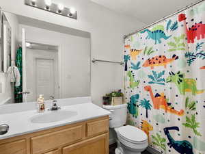 Bathroom with vanity, a large mirror toilet, and full shower