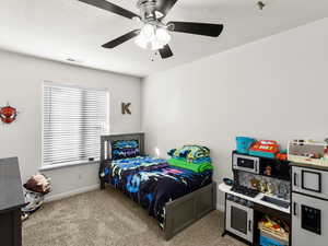 Carpeted bedroom with ceiling fan and a textured ceiling