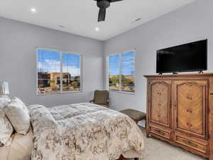 Carpeted bedroom featuring ceiling fan