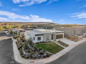 View of front of home featuring a mountain view, a garage, and a front lawn