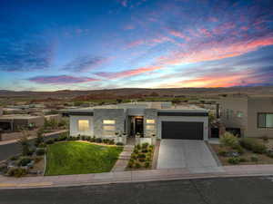 View of front of home with a lawn, a mountain view, and a garage