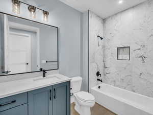 Full bathroom featuring toilet, vanity, and tiled shower / bath