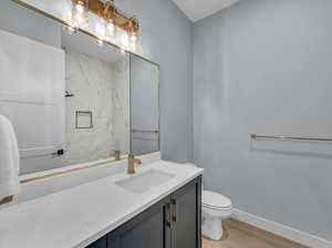 Bathroom featuring hardwood / wood-style flooring, vanity, and toilet