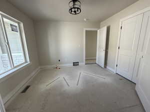 Interior space with baseboards, multiple windows, visible vents, and a closet