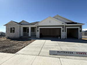 View of front of home with a garage, driveway, board and batten siding, and a porch