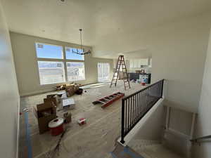 Interior space with baseboards, a chandelier, and a textured ceiling