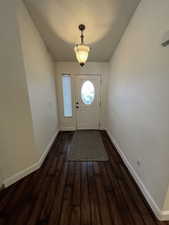 Doorway with dark wood-type flooring