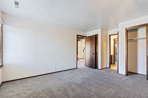 Unfurnished bedroom featuring light colored carpet and a closet