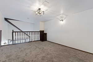 Carpeted empty room with a chandelier