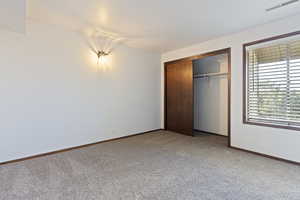 Unfurnished bedroom with carpet and a closet