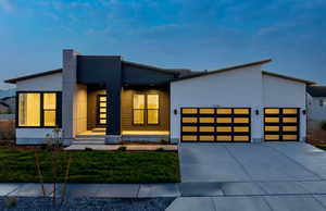 Contemporary home featuring a front yard and a garage