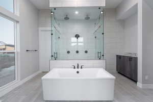 Bathroom featuring vanity and shower with separate bathtub