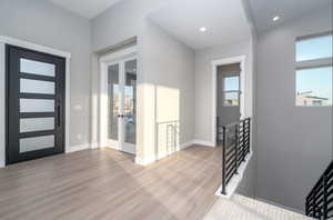 Entrance foyer featuring french doors, light hardwood / wood-style flooring, and plenty of natural light