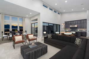 Living room featuring light colored carpet and a high ceiling