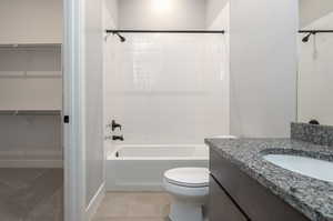 Full bathroom featuring tile patterned floors, vanity, toilet, and tiled shower / bath