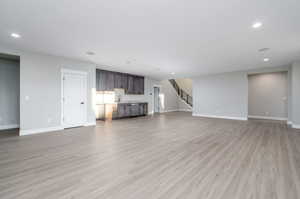 Unfurnished living room with sink and light hardwood / wood-style flooring