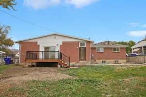 Rear view of property featuring a deck and a yard