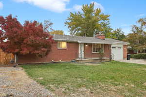 View of front of house featuring a garage and a front yard