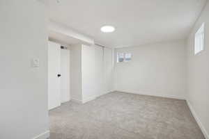 Basement featuring light colored carpet