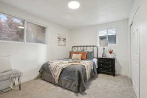 Bedroom with light carpet and a closet