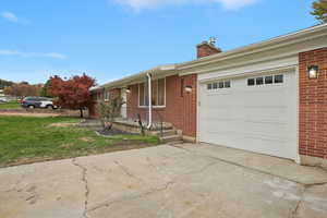 Ranch-style home featuring a garage and a front lawn