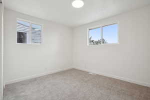 Carpeted empty room featuring plenty of natural light