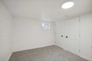 Basement featuring light carpet