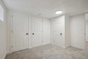 Unfurnished bedroom featuring light colored carpet and a textured ceiling