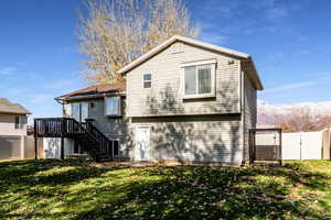 Back of property with a mountain view and a yard